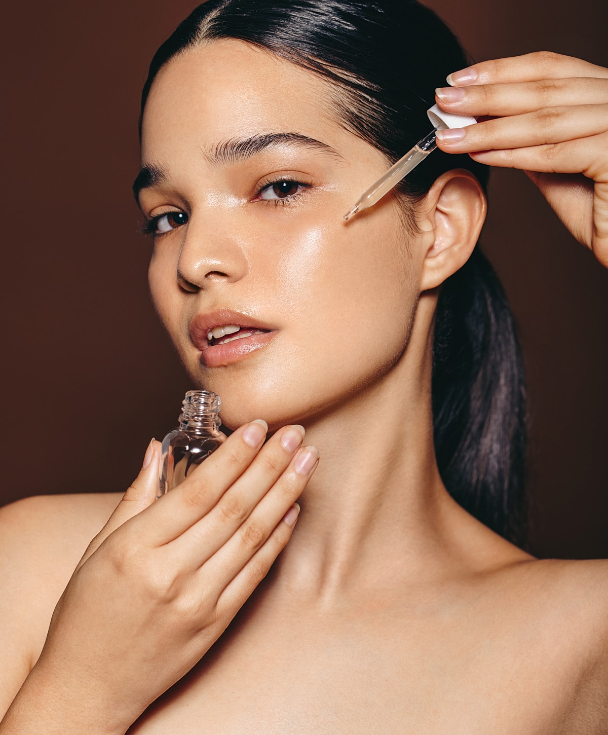 Applying serum to glowing skin.