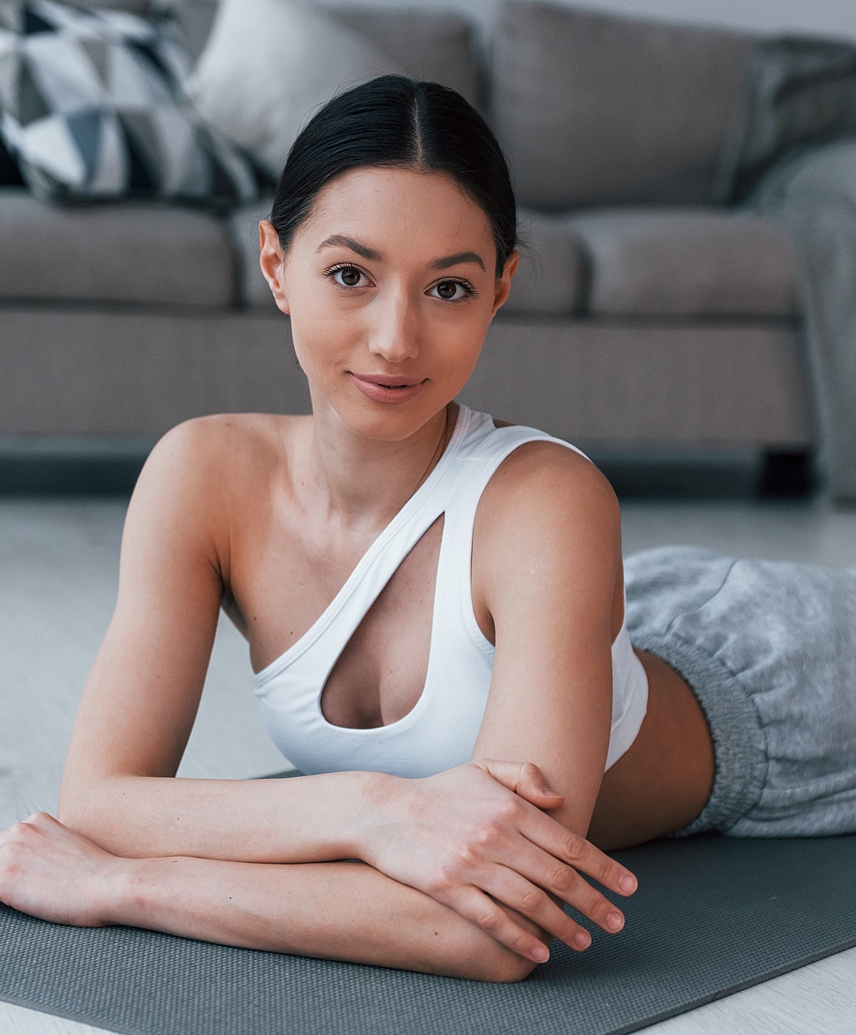 Woman relaxing on yoga mat indoors.