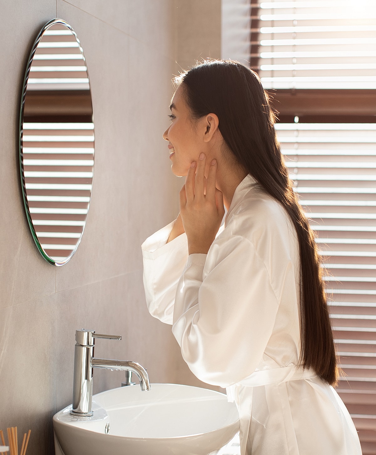 Woman admiring her reflection in a bathroom.
