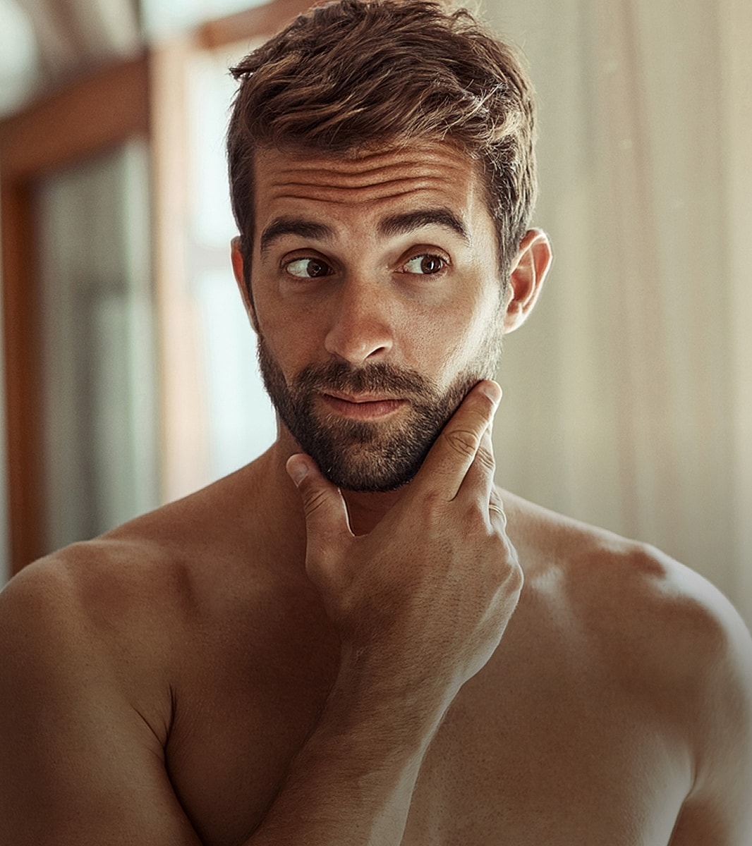 Man contemplating in a bright indoor setting.