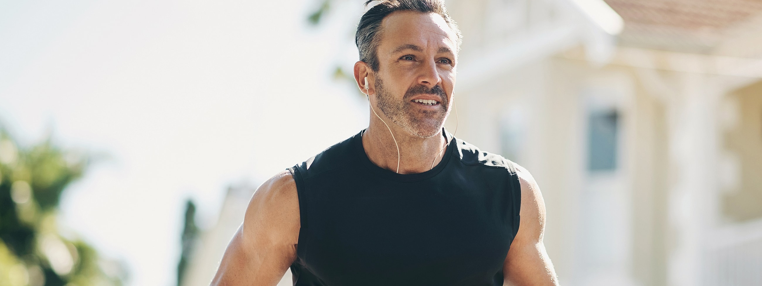 Man jogging outdoors with headphones on.